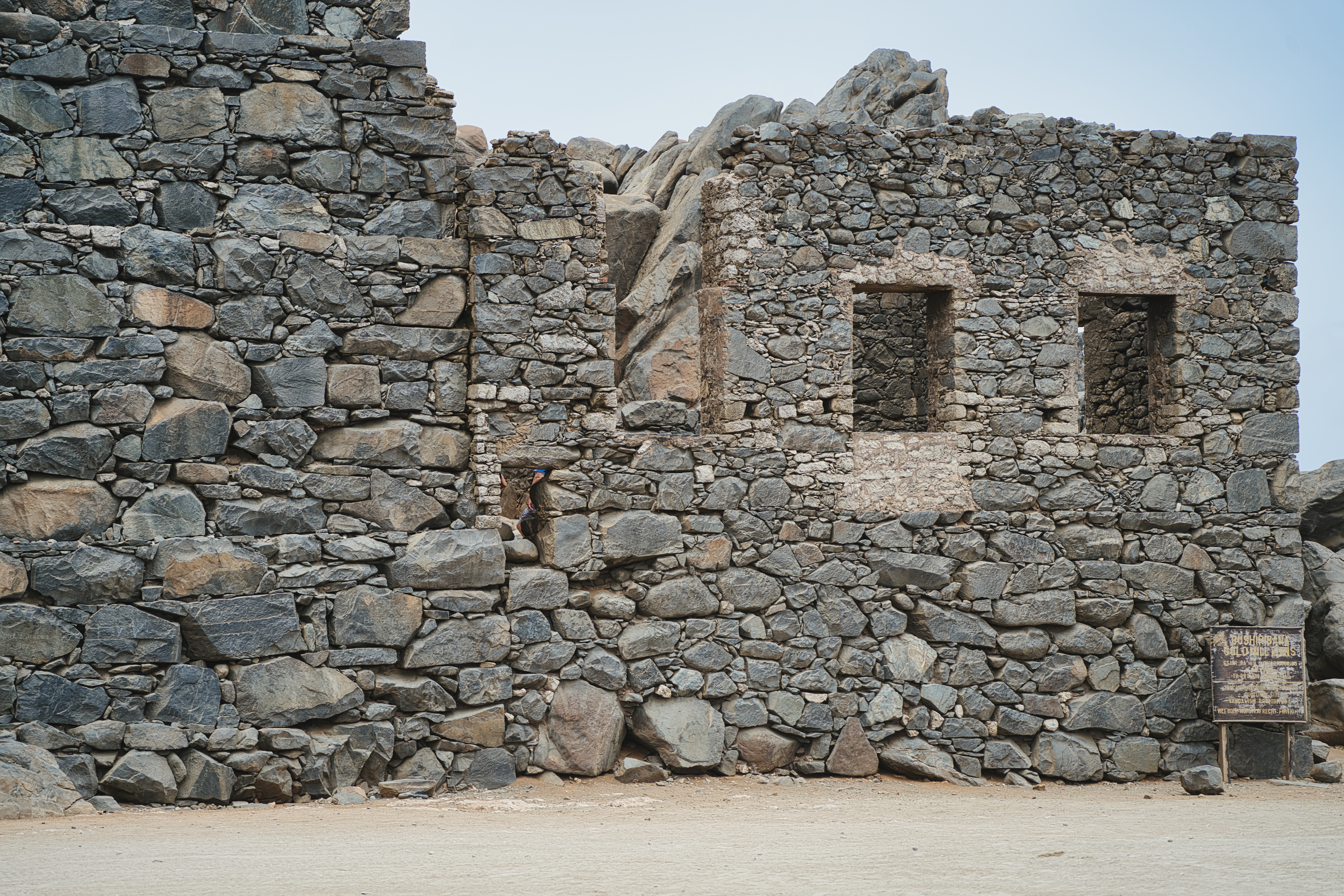 Stacked-stone walls of an old ruin, weathered rock in bright sun